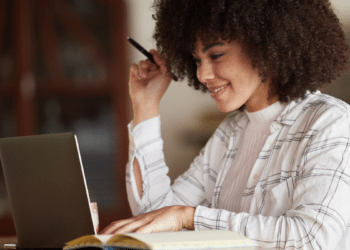 Mulher consulta vagas de concursos públicos em São Paulo pelo notebook.