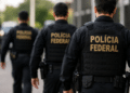 Agentes da Polícia Federal fardados caminham com a identificação da corporação nas costas Título: Concurso da Polícia Federal terá convocação adicional de aprovados.