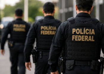Agentes da Polícia Federal fardados caminham com a identificação da corporação nas costas Título: Concurso da Polícia Federal terá convocação adicional de aprovados.