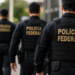 Agentes da Polícia Federal fardados caminham com a identificação da corporação nas costas Título: Concurso da Polícia Federal terá convocação adicional de aprovados.