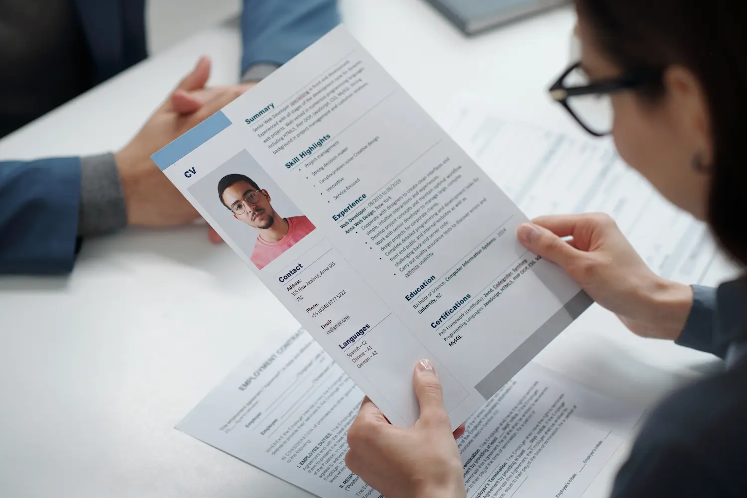 Foto no currículo durante avaliação profissional Recrutadora analisa currículo com foto durante processo seletivo.