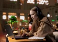 Estudante participa de curso online pelo notebook em uma biblioteca.