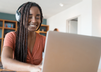 Estudante utilizando notebook para acessar informações sobre cursos técnicos gratuitos.