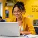 Mulher realizando inscrição em curso gratuito de qualificação profissional usando notebook em ambiente de estudo