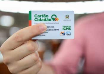 Mão segura o Cartão Cidadão do Devolve ICMS, usado para receber o benefício em 2026