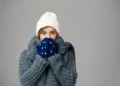 Pessoa agasalhada em ambiente de inverno refletindo sobre a dúvida gramatical se a palavra “frio” possui forma no diminutivo na língua portuguesa.