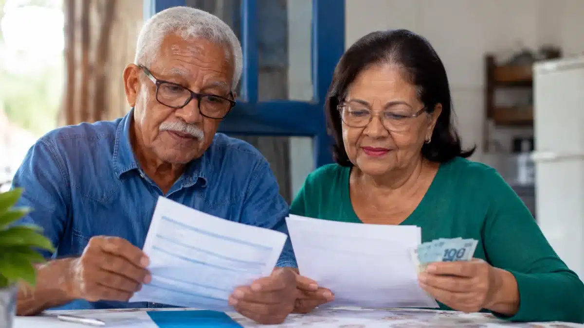 INSS - Devolução de descontos indevidos Aposentado e pensionista analisam documentos para verificar descontos indevidos em benefícios do INSS.