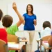Professora em sala de aula com alunos durante atividade educativa sobre cidadania e formação escolar.