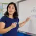 Professora aponta para quadro com as formas “vêem” e “veem” durante aula de português
