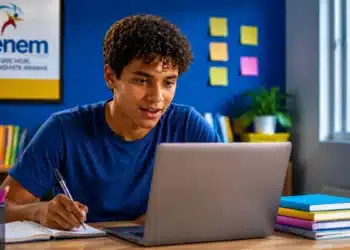Jovem estudante utiliza notebook e faz anotações, representando os exercícios e simulados gratuitos oferecidos pelo MEC Enem.