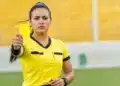 Mulher em campo segurando cartão amarelo durante partida esportiva, representando o feminino correto de árbitro.