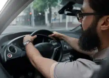 Motorista ao volante de veículo, representando a parceria entre CAIXA e 99 para financiamento com possibilidade de cashback.