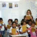 Professora conduz atividade de leitura com estudantes em sala de aula durante iniciativa de formação educacional.