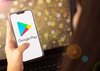 Pessoa segurando celular com aplicativo Google Play aberto, representando o passo a passo para solicitar reembolso de aplicativos e jogos comprados na plataforma.