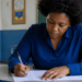 Mulher preenche formulário em sala de aula durante inscrição para certificador do Inep.