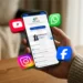 Pessoa segurando celular com aplicativo Meu INSS aberto e ícones de redes sociais representando os canais oficiais de atendimento do Instituto Nacional do Seguro Social.