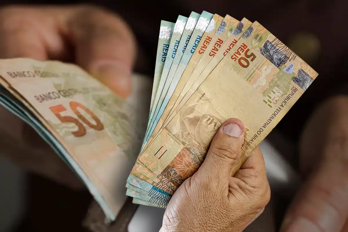 Saque Calamidade do FGTS - Liberação em situações de desastres Mãos segurando e contando cédulas de real, representando o recurso emergencial liberado pelo Saque Calamidade do FGTS.