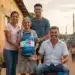 Família sorrindo com o botijão do Gás do Povo representa o acesso gratuito garantido às famílias