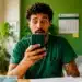 Homem olhando para o celular com expressão de surpresa, representando a consulta ao lote especial de restituição do Imposto de Renda.
