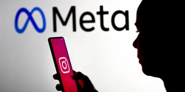 Pessoa segurando celular com aplicativo do Instagram em destaque diante da marca Meta, representando a interrupção de recurso de inteligência artificial após críticas.