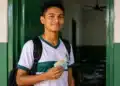 Estudante da EJA em escola pública segurando dinheiro, representando a parcela de R$ 1.000 do programa Pé-de-Meia.