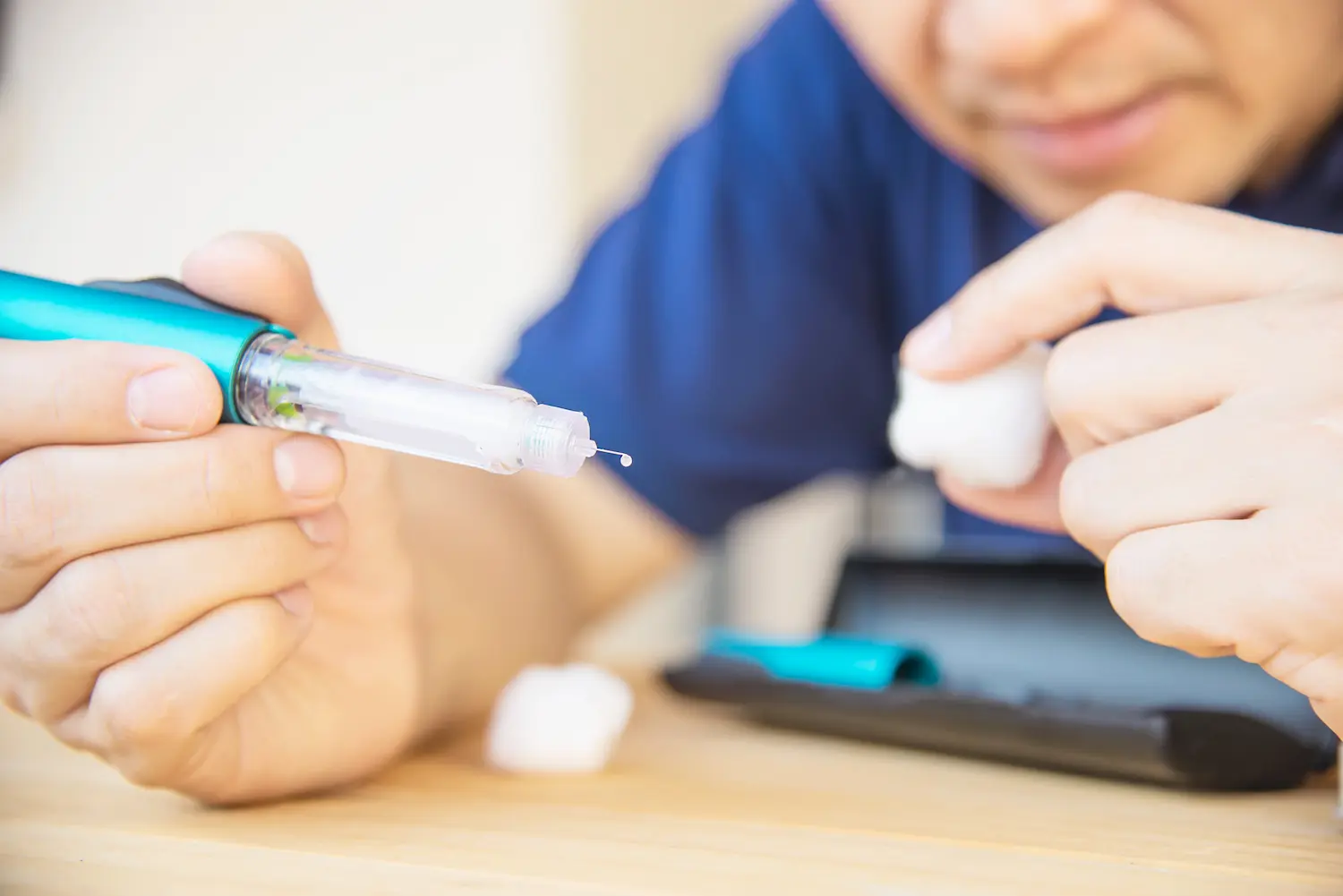 Mounjaro falsificado Pessoa prepara caneta injetável, ilustrando os riscos do uso de medicamentos falsificados ou sem registro.