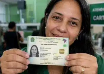 Cidadã segura a Carteira de Identidade Nacional (CIN), representando a emissão do novo documento em cartórios.