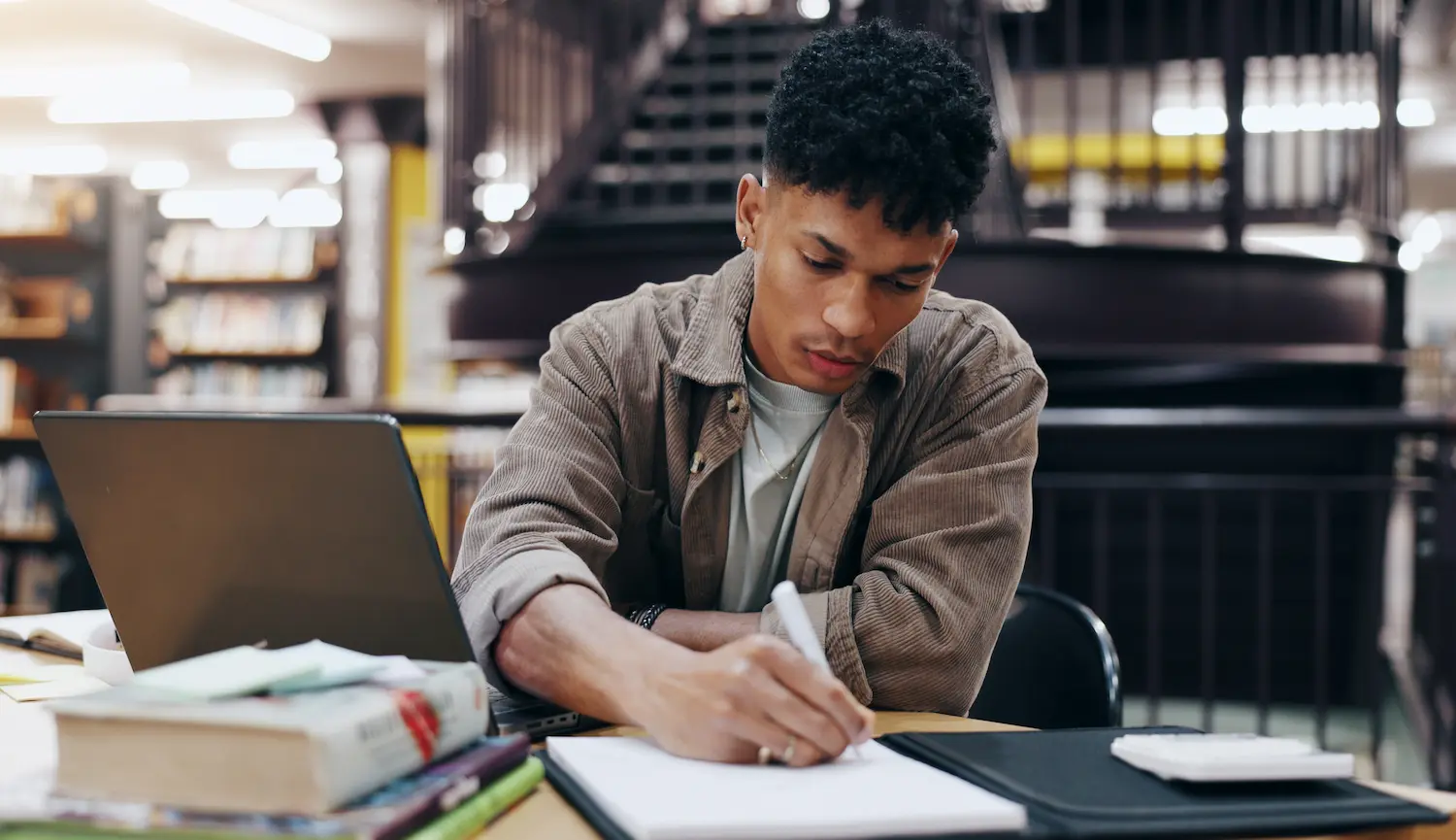Preparação para o concurso da Receita Federal 2026 Estudante se preparando para o novo concurso da Receita Federal com livros, computador e materiais de estudo.