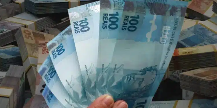 Notas de dinheiro em reais em destaque, representando pagamentos do INSS de até R$ 8.475,55, nos dias 2 e 3 de julho de 2026.