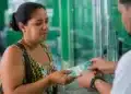 Mulher recebendo pagamento do Bolsa Família em atendimento presencial, representando os pagamentos da primeira semana do calendário, entre os dias 20 e 24 de julho.