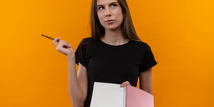 Mulher com caderno e lápis demonstra dúvida sobre a grafia correta da palavra privilégio.