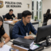 Estagiários trabalham em computadores e analisam documentos na Polícia Civil de Roraima.
