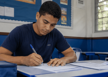 Jovem preenche formulário em sala de aula durante inscrição para processo seletivo.