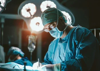 Médico realizando procedimento cirúrgico em hospital, representando o Projeto Mais Médicos Especialistas com oferta de capacitação e bolsas.