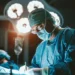 Médico realizando procedimento cirúrgico em hospital, representando o Projeto Mais Médicos Especialistas com oferta de capacitação e bolsas.