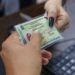 Pessoa segurando uma carteira de identidade no modelo antigo diante do rosto