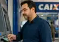 Beneficiário sacando dinheiro em caixa eletrônico da Caixa, representando a liberação das RPVs a partir de 30 de julho.