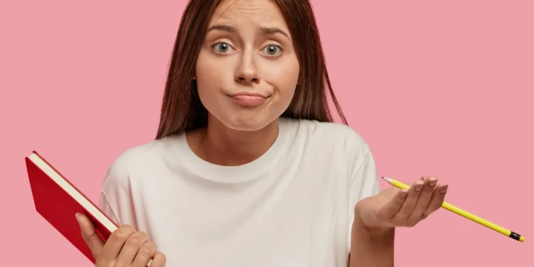 Mulher com expressão de dúvida segurando livro e lápis para ilustrar dúvida sobre a escrita correta de sanguessuga ou sangue-suga.
