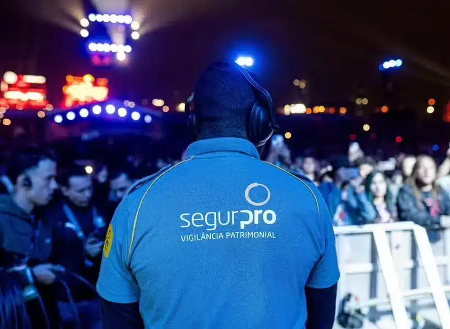 Vagas da SegurPro para trabalhar no Rock in Rio 2026 Vigilante da SegurPro acompanha o público durante um festival de música.