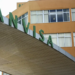 Letreiro verde ANVISA na entrada do prédio administrativo laranja com janelas em Brasília.