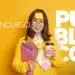 Jovem mulher asiática sorridente, roupas amarelas, segurando café e pastas, notas adesivas, fundo amarelo, escrito Concurso Público.