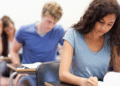 Estudantes concentrados realizando prova em sala de aula.