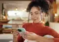 Mulher utiliza o celular para acessar serviços digitais pela internet.