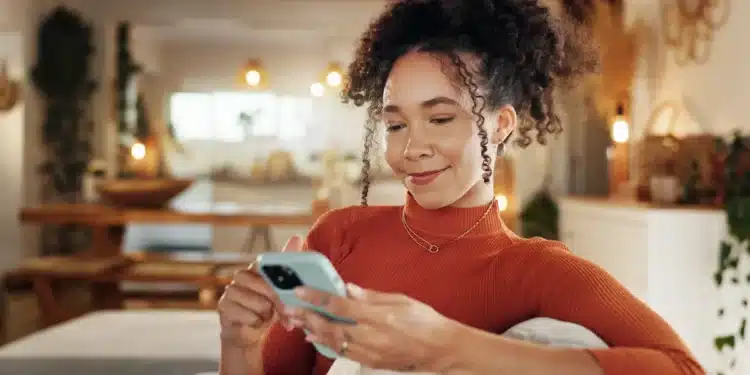Mulher utiliza o celular para acessar serviços digitais pela internet.