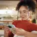 Mulher utiliza o celular para acessar serviços digitais pela internet.