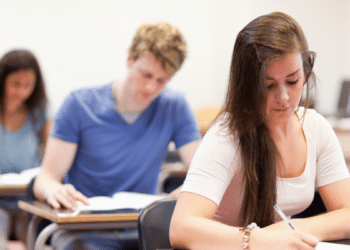 Estudantes focados realizando prova em sala de aula.