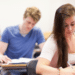 Estudantes focados realizando prova em sala de aula.