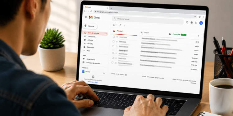 Homem mexendo em notebook exibindo Gmail aberto com e-mails recentes.