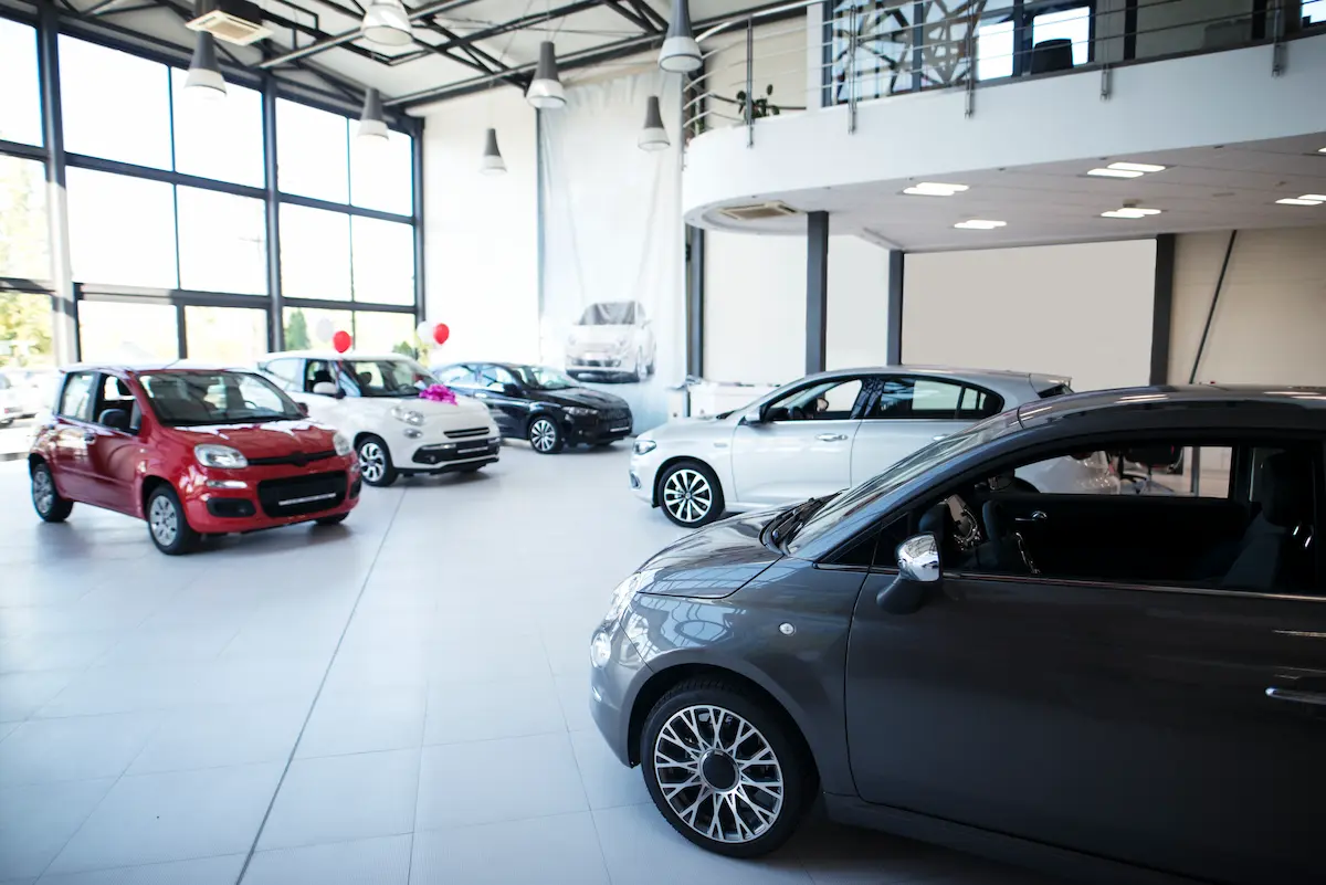 Carros em concessionária representando os veículos novos de até R$ 200 mil financiados pelo Move Brasil.