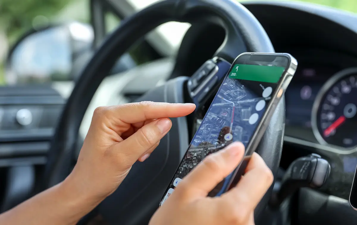 Pergunte ao Maps Pessoa utilizando mapa com inteligência artificial no celular dentro de um carro.